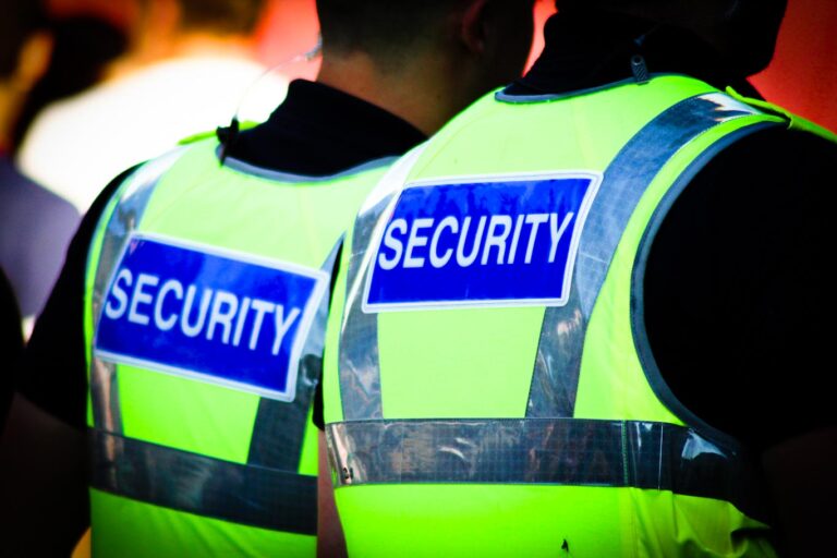 Image,Of,Two,Male,Security,Guards,With,Bright,Tops,On.